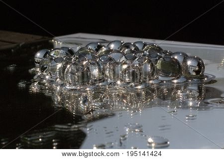 Transparant gelly balls on a mirror with water shining in the sun