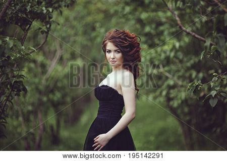 Portrait of a beautiful brunette outside. The girl is walking in the woods