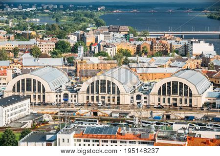 Riga, Latvia. Aerial Cityscape In Sunny Summer Evening. Top View Of Landmarks - Bus Station Riga International Coach Terminal And Riga Central Market