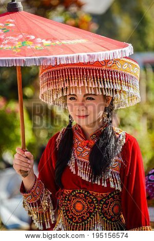 CHIANGMAI THAILAND - JANUARY 25 2015: Hill Tribe girl holding local paper umbrella in parade of 22nd Traditional Skirt Fabric and The Indigenous Product and Culture Festival in Mae Chaem Chiangmai Thailand