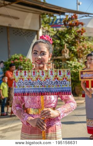 Chiangmai Thailand - January 25 2015: Indigenous girl with local traditional costume holding board of fabric design name in parade of 22nd Traditional Skirt Fabric and The Indigenous Product and Culture Festival in Mae Chaem Chiangmai Thailand