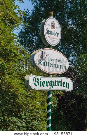 ESSEN NRW GERMANY - JULY 23 2014: Advertising Sign in Essen district of Kettwig near the restaurant at the Kattenturm. Green and white striped wooden post with advertising surface.