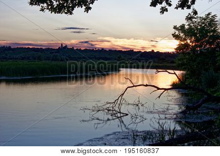 Beautiful shades and clouds in the sky are reflected in the river surface at the time of sunset.