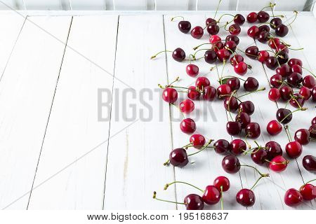 On a white wooden background cherry berries