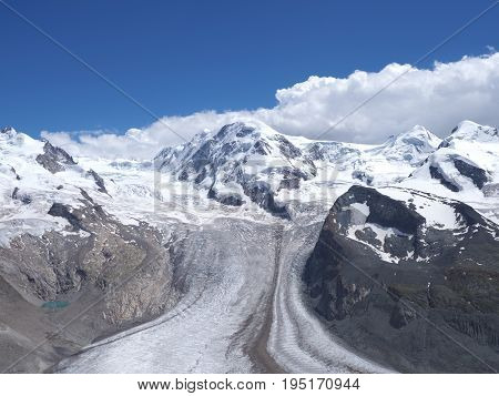 Monte Rosa, landscape of alpine glacier and Dufourspitze highest mount in swiss Alps at SWITZERLAND, from Gornergrat near Zermatt village, cloudy blue sky in 2017 warm sunny summer day, Europe on July