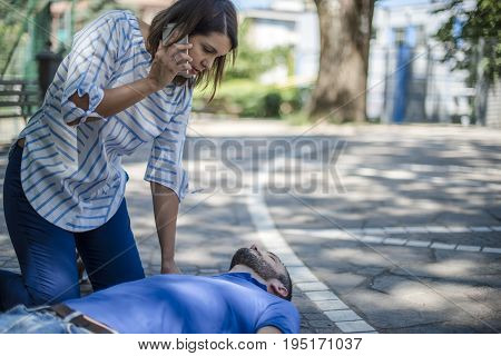 girl calling emergency service to assist a guy with cpr
