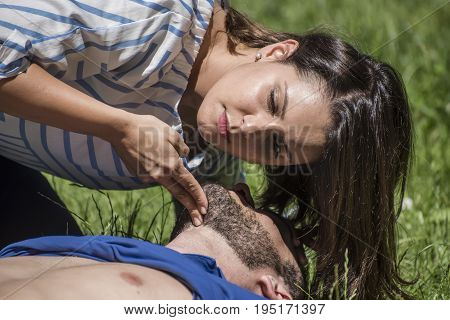 girl making cardiopulmonary resuscitation to an unconscious guy after heart attack