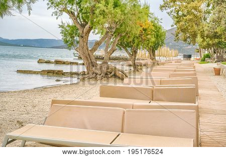 Picturesque beach with sun beds on the shore of the Mirabello Bay on the island of Crete Greece