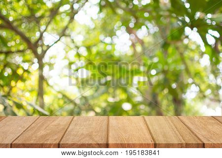 Empty wooden table top and sunny blurred bokeh background for product displa