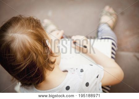 Beautiful child girl is preparing for exams (prescool education knowledge success responsibility concept)