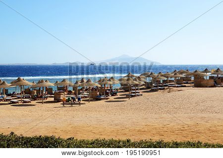 SHARM EL SHEIKH EGYPT - NOVEMBER 29: The tourists are on beach at popular hotel on November 29 2013 in Sharm el Sheikh Egypt. Up to 12 million tourists have visited Egypt in year 2013.