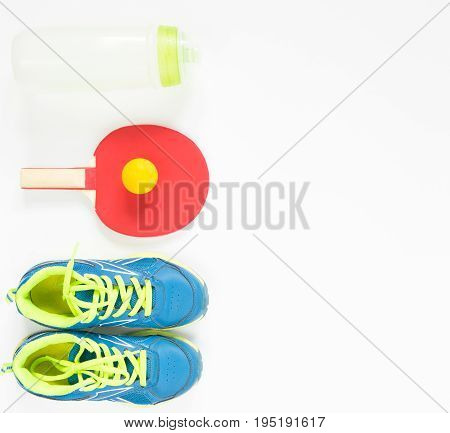 Sport background. Red ping-pong racket and orange ball . Flat lay blue treiners water bottle. Flat lay top view.