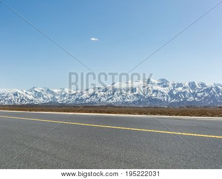 snow mountain background with empty asphalt road in golmud city China