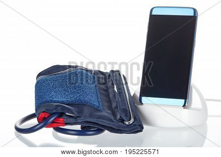 Electronic smart blood pressure monitor or sphygmomanometer with a phone or tablet hooked up to an inflatable arm cuff. This device is the modern version of the traditional medical instrument for health care.