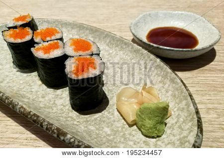 Ebiko maki sushi rolls - japanese food style in a ceramic plate.