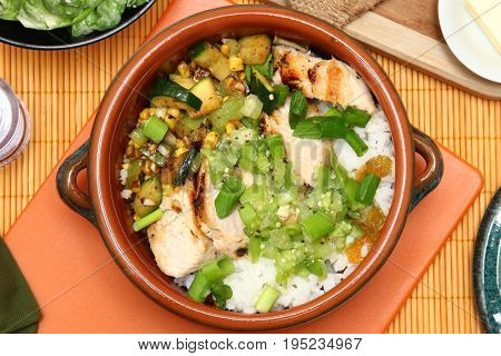 Seared Chicken and Tomatillo Salsa in Small Crockery Potl on table.