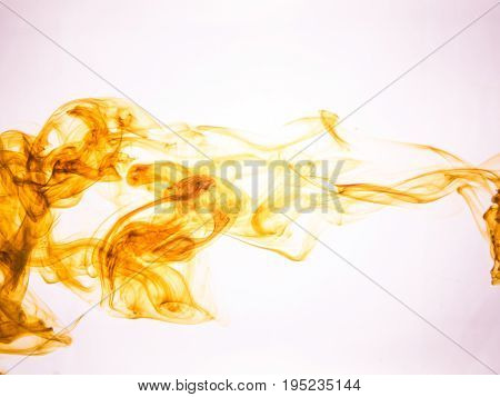 Ink swirl in a water on color background. The paint splash in the water. Soft dissemination a droplets of colored ink in water close-up. Abstract background. Explosion of splashes acrylic ink.