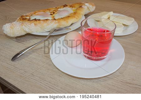 Adjarian khachapuri on a on a plate. Open pie with cheese in the shape of the boat. Delicious homemade khachapuri in Adjarian