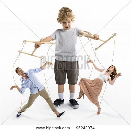 Little Boy Puppeteer Controlling Parents With Strings Isolated On White