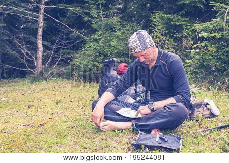 Bearded Traveler Is Studying Map While Sitting Barefoot