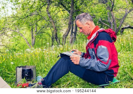 Puzzled Traveler Sits On A Green Meadow