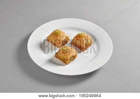 Round dish with turkish baclava isolated on grey background