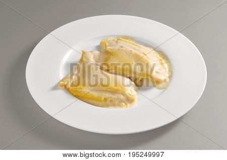Round plate with a portion of salty crepes isolated on grey background