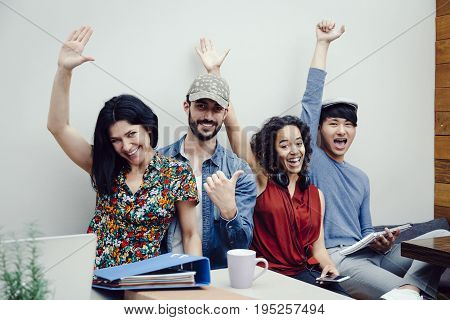 Group of four multiethnic entrepreneurs celebrating success of their new company