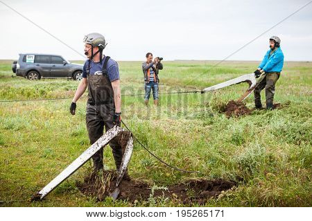 KIRILLOVKA UKRAINE - MAY 25 2016: Zaporizhia Trophy 2016. II stage of offroad trophy Ukrainian championship. Participants setting up ground anchors.