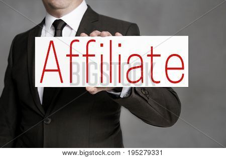 Affiliate signboard is held by businessman background