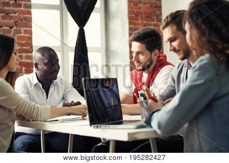 Teamwork concept.Young creative coworkers working with new startup project in modern office.Group of people analyze data on desktop computer.