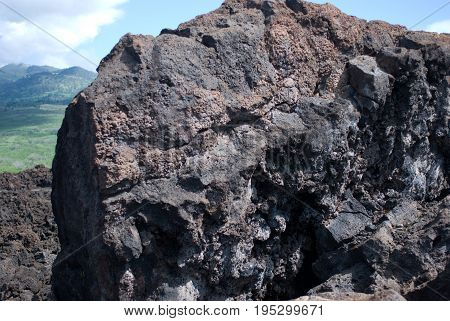 View of Black lava rocks line the shore at Keanae on the road to Hana in Maui, Hawaii