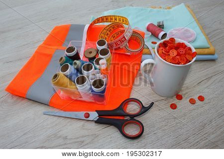 Sewing tools and sewing kit on wooden textured background. Sewing kit. Thread needles and cloth. tailor workspace with sewing and handmade tools