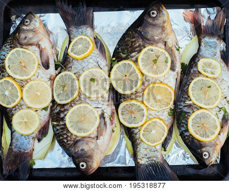 Fresh Uncooked Fish With Lemon Lie On Metal Baking Tray. Big Raw River Fish Before Baking. Top View
