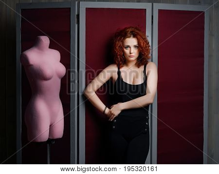 Women standing next pink pinktailor's dummy on the red screen