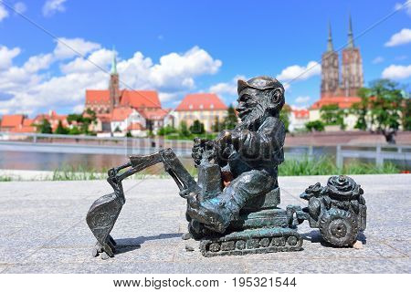 WROCLAW POLAND - JUNE 2017: The symbol of Wroclaw. A small gnome sculpture in the background of the panorama of Wroclaw.
