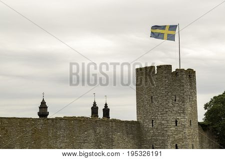 Town Wall in Visby Gotland with the Swedish flag and the Visby Cathedral.