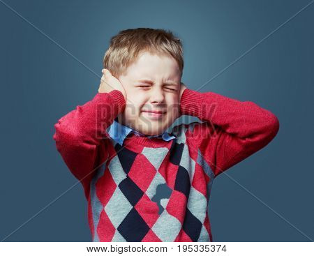 unhappy boy closing ears, isolated against grey