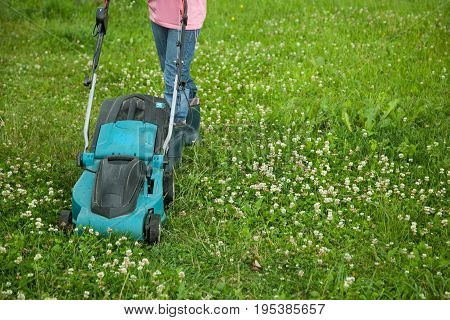 Closeup of grassmower moving on the grass