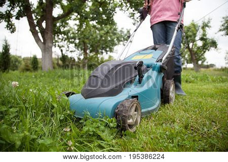 Closeup of grassmower moving on the grass