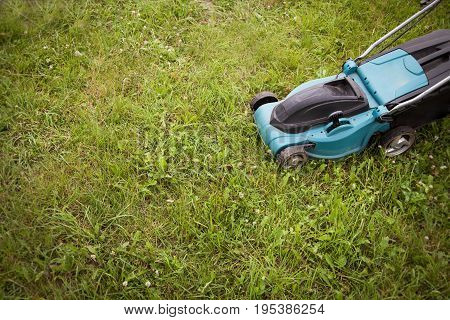Closeup of grassmower moving on the grass