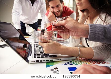 Teamwork concept.Young creative coworkers working with new startup project in modern office.Group of people analyze data on desktop computer.