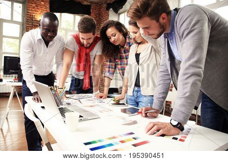 Teamwork concept.Young creative coworkers working with new startup project in modern office.Group of people analyze data on desktop computer.