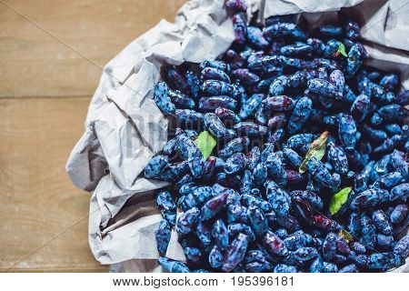 Fresh Honeysuckle Blue Berry Fruits With Leaf On A Wooden Background
