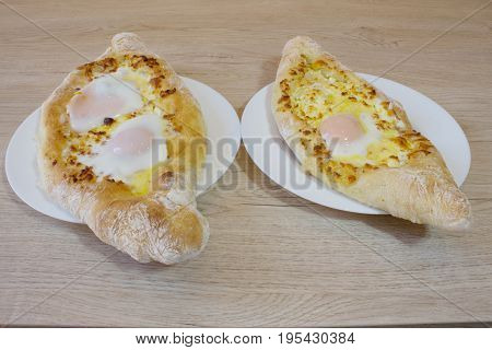 Adjarian khachapuri with eggs on the table. Delicious homemade khachapuri in Adjarian