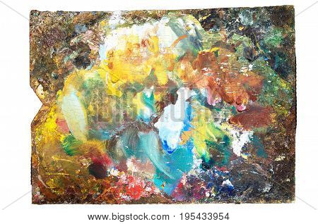 The artist's palette covered with paint in the process of his work close-up isolate.