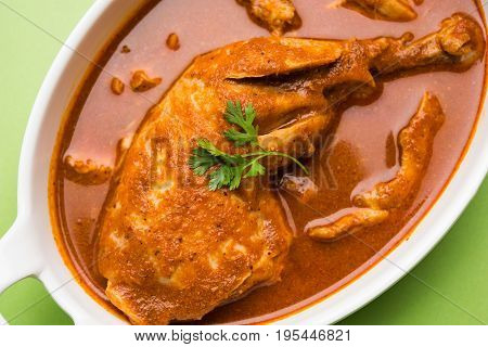 Indian spicy Chicken curry or masala chicken with prominent leg piece, popular recipe from India, selective focus
