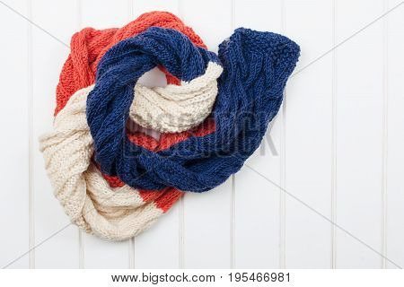 Colorful Woolly Hat And Scarf On White Wooden Background.