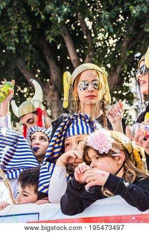 LIMASSOL, CYPRUS - FEBRUARY 26: Carnivalists in a silver cylinder hats joyfully follow the Limassol Municipality Band during the annual Carnival Parade, February 26, 2017 in Limassol.