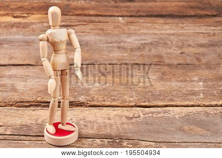 Wooden modeling figure, wooden background. Human wooden dummy standing on support.